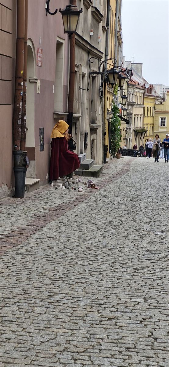 Brukowana uliczka Starego Miasta w Lublinie z grajkiem w stroju z epoki